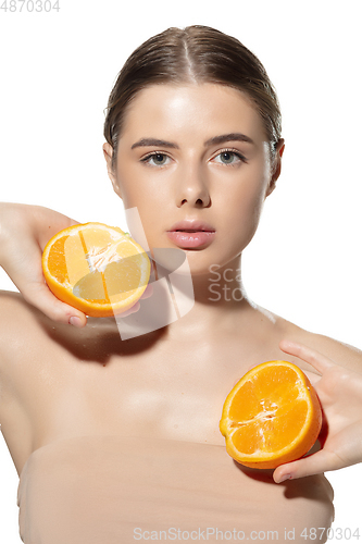 Image of Juicy. Beautiful young woman with halfs of orange over white background. Cosmetics and makeup, natural and eco treatment, skin care.