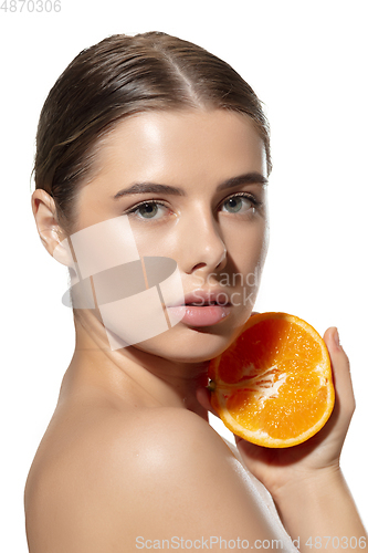 Image of Freshness. Beautiful young woman with half of orange over white background. Cosmetics and makeup, natural and eco treatment, skin care.