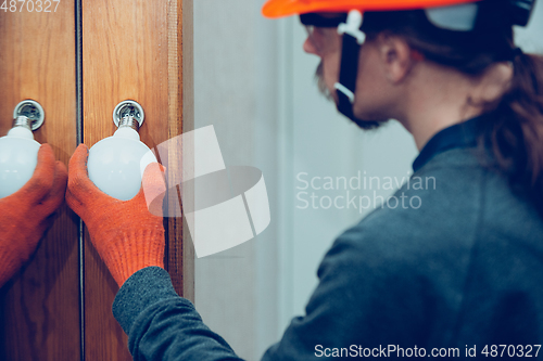 Image of Electrician replace the lamp. Closeup of man repairing a lamp. Hazardous concept, high voltage, risk, wiring replacement, technician\'s occupation