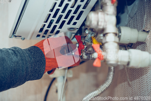 Image of Male hand closes the wick of a gas bottle, heater, shuts off the flow