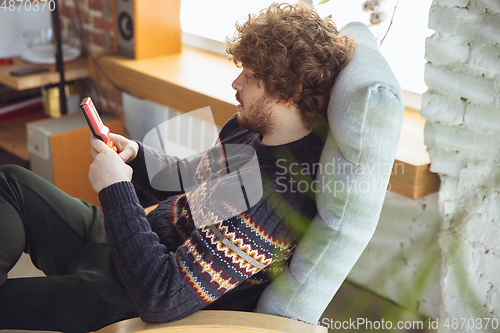 Image of Portrait of millenial boy using retro toys, meeting things from the past and having fun, nostalgic, expressive playing tetris