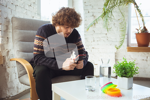 Image of Portrait of millenial boy using retro toys, meeting things from the past and having fun, nostalgic, expressive playing tetris