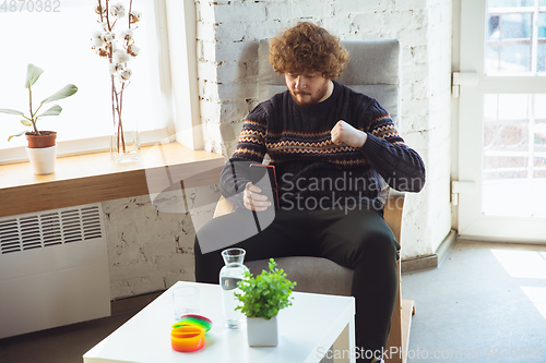 Image of Portrait of millenial boy using retro toys, meeting things from the past and having fun, nostalgic, expressive playing tetris