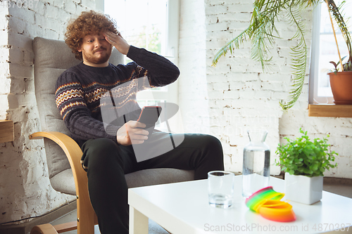 Image of Portrait of millenial boy using retro toys, meeting things from the past and having fun, nostalgic, expressive playing tetris