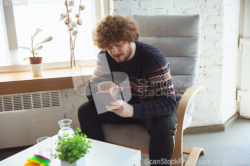 Image of Portrait of millenial boy using retro toys, meeting things from the past and having fun, nostalgic, expressive playing tetris