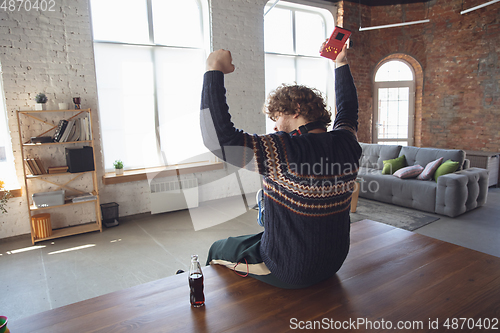 Image of Portrait of millenial boy using retro toys, meeting things from the past and having fun, nostalgic, expressive playing tetris