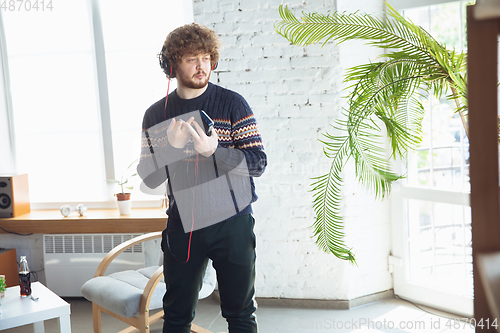 Image of Portrait of millenial boy using retro toys, meeting things from the past and having fun, nostalgic, listen to music with cassette player