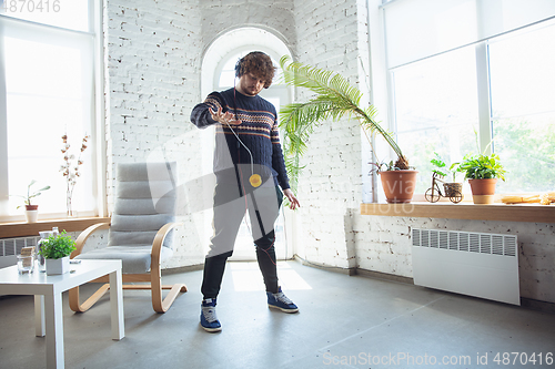 Image of Portrait of millenial boy using retro toys, meeting things from the past and having fun, nostalgic, playing yo-yo