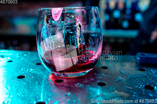 Image of Close up of alcoholic cocktail, beverage, drink in multicolored neon light