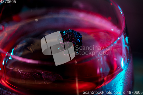 Image of Close up of alcoholic cocktail, beverage, drink in multicolored neon light