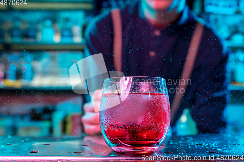 Image of Close up of alcoholic cocktail, beverage, drink in multicolored neon light