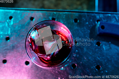 Image of Close up of alcoholic cocktail, beverage, drink in multicolored neon light