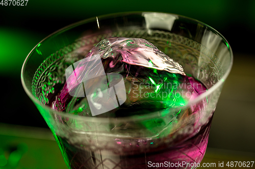 Image of Close up of alcoholic cocktail, beverage, drink in multicolored neon light