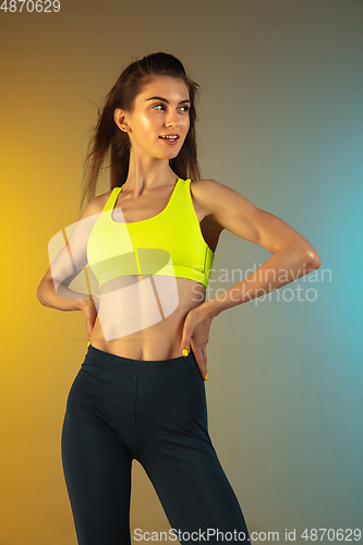 Image of Fashion portrait of young fit and sportive woman on gradient background. Perfect body ready for summertime.