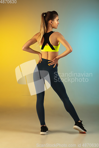 Image of Fashion portrait of young fit and sportive woman on gradient background. Perfect body ready for summertime.