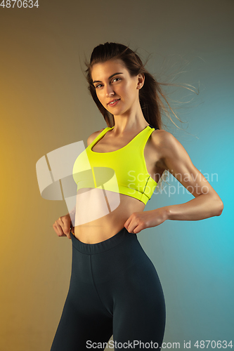 Image of Fashion portrait of young fit and sportive woman on gradient background. Perfect body ready for summertime.