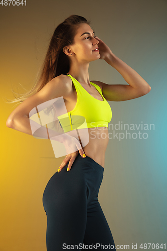 Image of Fashion portrait of young fit and sportive woman on gradient background. Perfect body ready for summertime.