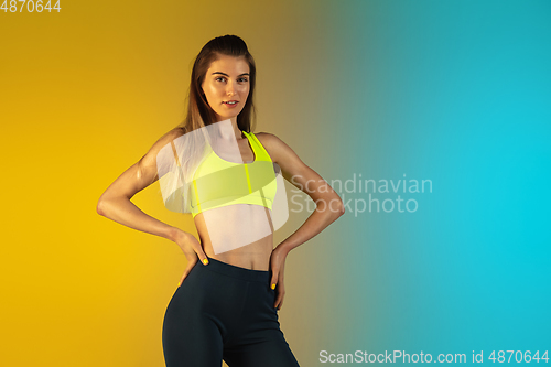 Image of Fashion portrait of young fit and sportive woman on gradient background. Perfect body ready for summertime.