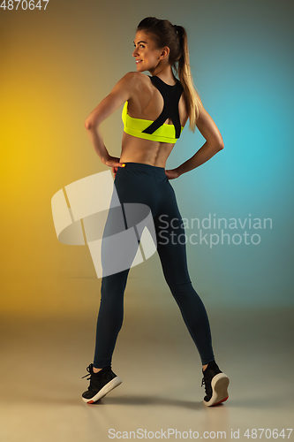 Image of Fashion portrait of young fit and sportive woman on gradient background. Perfect body ready for summertime.