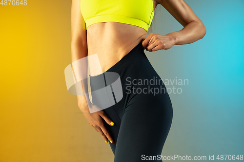 Image of Close up of young and sportive woman with fit belly and well-kept skin on gradient background. Perfect body ready for summertime.