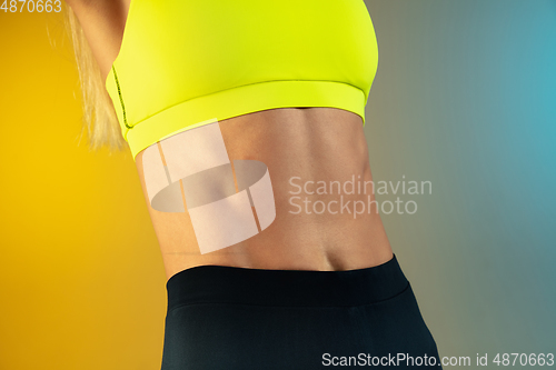 Image of Close up of young and sportive woman with fit belly and well-kept skin on gradient background. Perfect body ready for summertime.