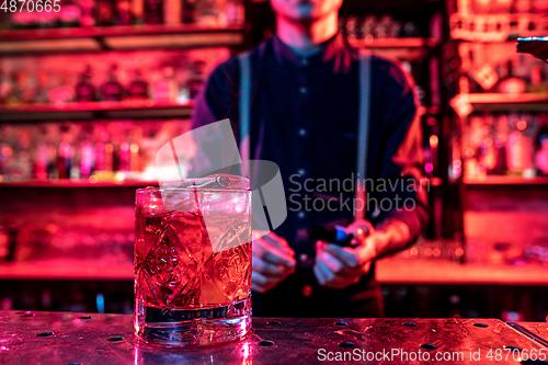 Image of Close up of alcoholic cocktail, beverage, drink, glass full of ice in multicolored neon light