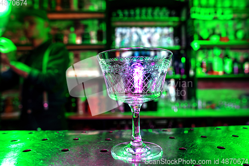 Image of Close up of graceful drinking glass on a bar counter, preparation for a cocktail