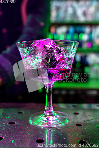 Image of Close up of alcoholic cocktail, beverage, drink, prepared by professional barman in multicolored neon light
