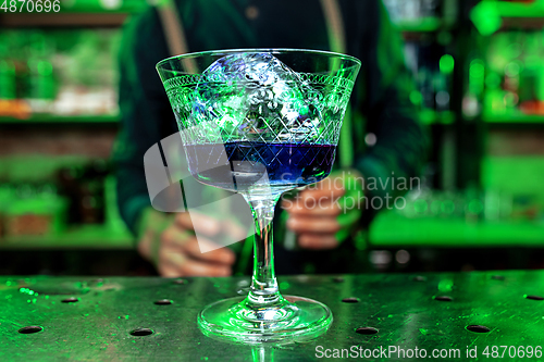 Image of Close up of alcoholic cocktail, beverage, drink, prepared by professional barman in multicolored neon light