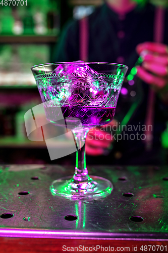 Image of Close up of alcoholic cocktail, beverage, drink, prepared by professional barman in multicolored neon light