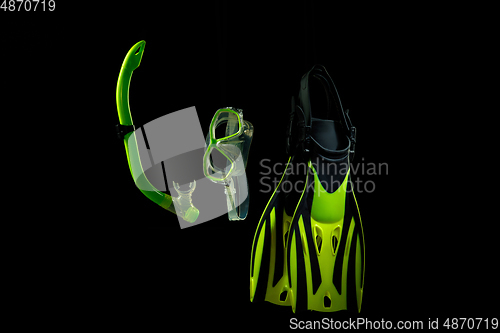 Image of Professional sport equipment isolated on black studio background. Swimming flippers and mask.