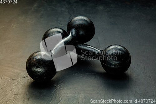 Image of Professional sport equipment isolated on black studio background. Black gym weights.