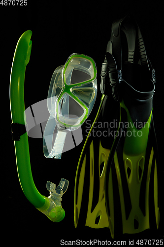 Image of Professional sport equipment isolated on black studio background. Swimming flippers and mask.