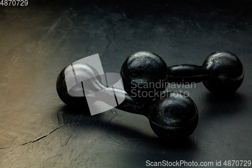 Image of Professional sport equipment isolated on black studio background. Black gym weights.