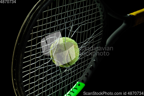 Image of Professional sport equipment isolated on black studio background. Tennis racket and ball.