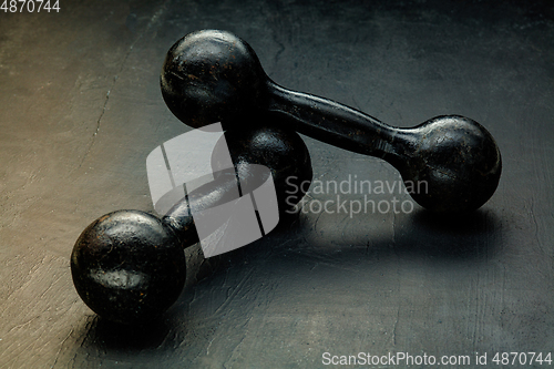 Image of Professional sport equipment isolated on black studio background. Black gym weights.