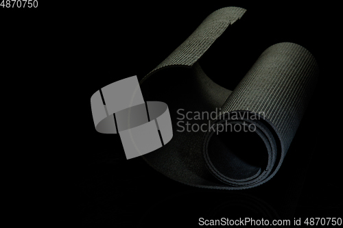 Image of Professional sport equipment isolated on black studio background. Exercise mat.