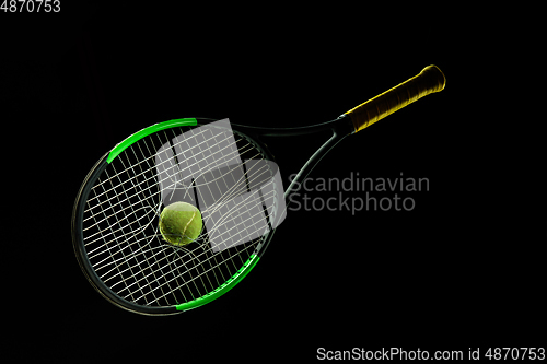 Image of Professional sport equipment isolated on black studio background. Tennis racket and ball.