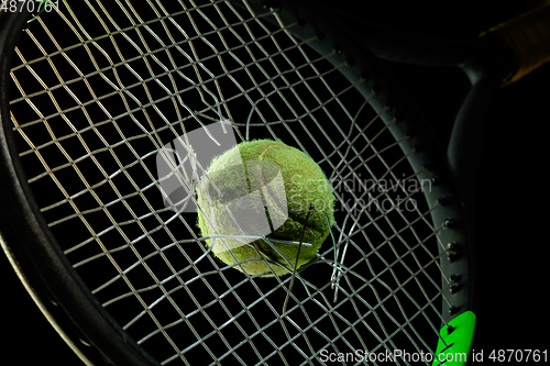 Image of Professional sport equipment isolated on black studio background. Tennis racket and ball.