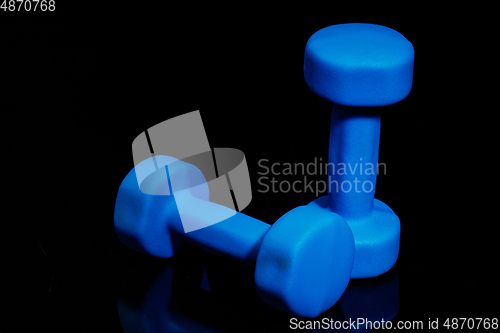 Image of Professional sport equipment isolated on black studio background. Blue gym weights.