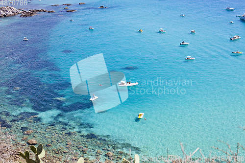 Image of Boats near a rock stone coast. Scenic view of tipycal rocky coas