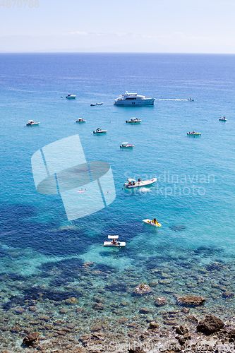 Image of Boats near a rock stone coast. Scenic view of tipycal rocky coas