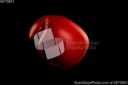 Image of Professional sport equipment isolated on black studio background. Boxers red glove.