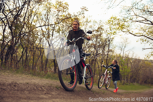 Image of Best friends having fun near countryside park, riding bikes, spending time healthy