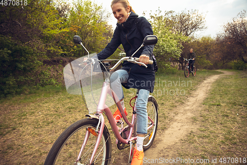 Image of Best friends having fun near countryside park, riding bikes, spending time healthy