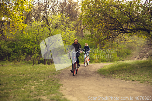 Image of Best friends having fun near countryside park, riding bikes, spending time healthy