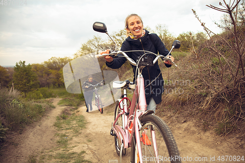 Image of Best friends having fun near countryside park, riding bikes, spending time healthy