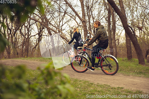 Image of Best friends having fun near countryside park, riding bikes, spending time healthy