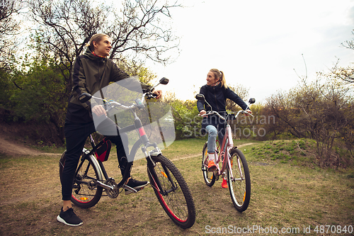 Image of Best friends having fun near countryside park, riding bikes, spending time healthy