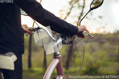 Image of Close up of young man having fun near countryside park, riding bike, traveling at spring day